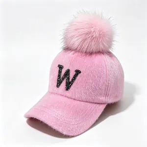 Close-up of pink faux mink fur baseball cap with rhinestone W and large pom-pom