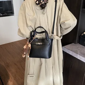 Elegant black pebbled leather bucket bag featuring silver-tone lock and cute bear charm