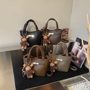 Premium leather bucket handbags with cute teddy bear charms in four versatile colors