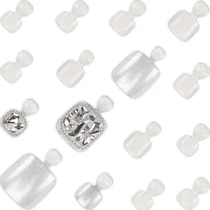 Vue détaillée d'ongles de pieds blancs et argentés pailletés avec des strass.