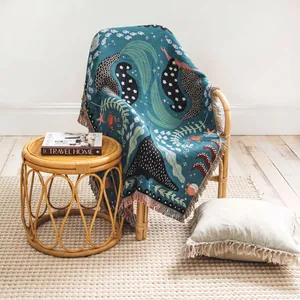 Macro view showing the intricate woven texture and mermaid pattern on the throw blanket