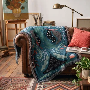 Detailed view of a bohemian woven throw blanket with ocean motifs on a leather sofa