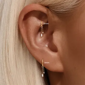 Close-up detail of 6mm and 8mm gold dangling hoop earrings with marquise charms