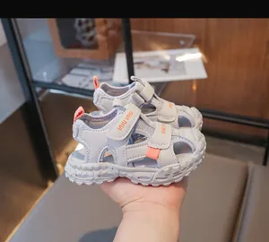 Dettaglio di sandali grigi in mesh per bambini con suole morbide e cinturini in velcro regolabili