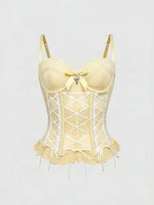 Close-up detail of a cream lace corset tank top with a cross charm and ribbon lacing