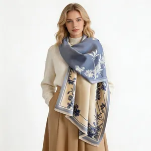 Elegant cashmere-like shawl with blue and beige magnolia flower patterns worn by a model