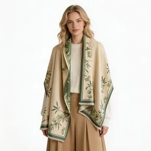 Model wearing a thick beige faux cashmere shawl with green magnolia floral patterns