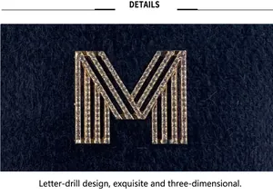 Close-up detail of a sparkling rhinestone M logo on a navy velvet baseball cap