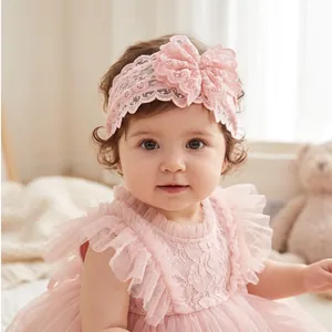 Vue détaillée d'un bébé portant un large bandeau en dentelle rose avec une fleur.