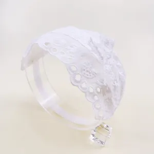 Vue détaillée d'un bandeau en dentelle blanche pour bébé avec broderie et nœud.