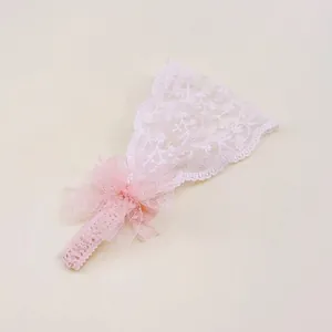 Détail de la texture en dentelle florale rose délicate sur un large bandeau pour bébé