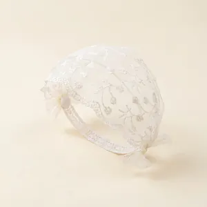 Bandeau délicat en dentelle blanche pour bébé avec broderie florale et nœuds latéraux