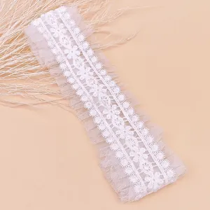 Gros plan sur un élégant bandeau floral en dentelle blanche pour bébé avec des volants