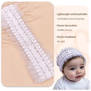 Vue détaillée du motif en dentelle blanche complexe sur un bandeau doux pour bébé