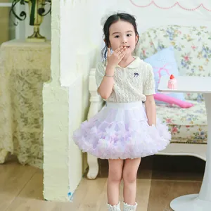 Detailed view of the colorful layered fluffy rainbow tutu skirt worn by a young girl model