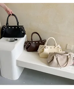 Vintage rivet tote handbags in four colors shown on a minimalist white display