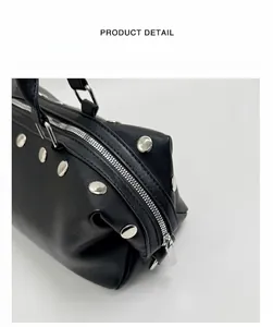 Close-up of black rivet handbag showing silver hardware and zipper detail