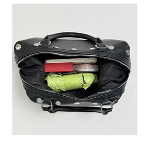 Top view of a black rivet handbag showing spacious internal storage for daily essentials