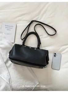 Detailed view of a retro black handbag featuring silver rivet accents and a top handle