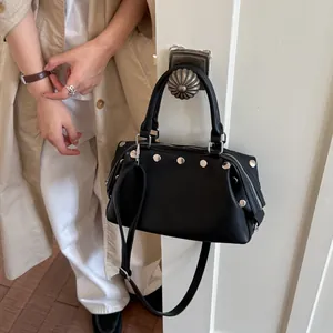 Vintage black rivet handbag for women, stylish crossbody tote bag shown on a door handle