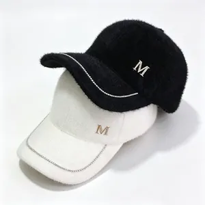 Close-up detail of fuzzy mink fleece baseball caps with rhinestone chain and M logo