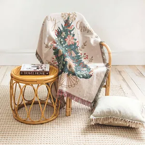 Woven Christmas tree throw blanket with tassels draped elegantly on a rattan chair