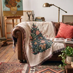 Cozy Christmas tree woven throw blanket with fringe on a leather sofa