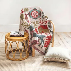 Detail view of a woven Christmas throw blanket with reindeer and snowflake patterns