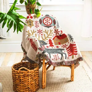 Close-up of a festive woven Christmas throw blanket with reindeer and snowflake designs