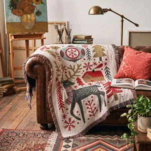 Detailed view of a cozy Christmas themed woven blanket with reindeer and tassels