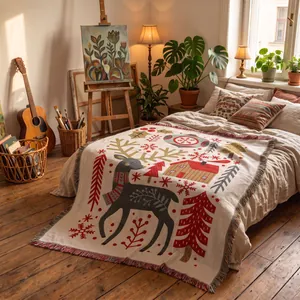 Christmas reindeer woven throw blanket displayed on a bed in a cozy artistic bedroom setting