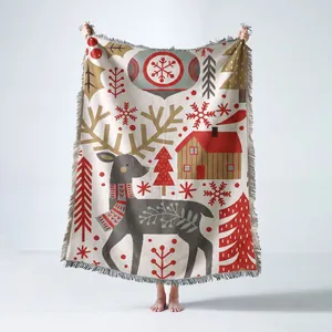Woven Christmas throw blanket featuring reindeer and snowflake patterns with fringe edges
