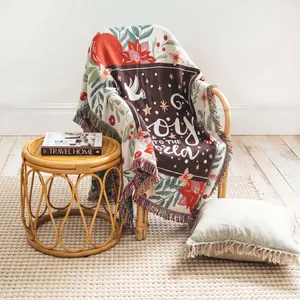 Cozy woven throw blanket with Joy to the World text in a warm home setting