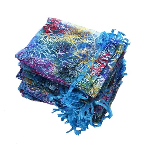 Detail von blauen Organza-Geschenkbeuteln mit buntem Korallenmuster und Kordelzug.