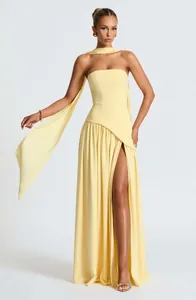 Full view detail of an elegant yellow strapless maxi dress with high slit and scarf.