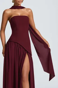 Elegant burgundy strapless evening gown with high slit and matching neck drape detail.