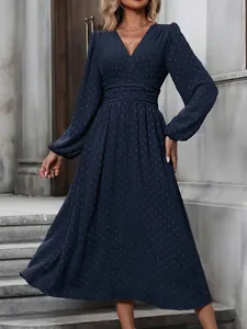 Detail of navy lantern sleeve maxi dress with pleated waist and textured pattern.