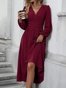 Close-up of wine red Swiss dot maxi dress featuring elegant pleated waist and lantern sleeves.