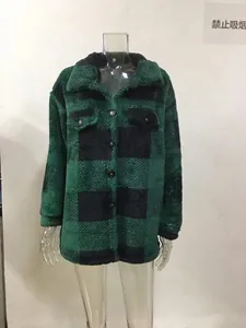 Primo piano di una giacca in pile a scacchi verde e nero con bottoni e tasche sul petto.