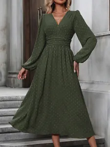 Elegant dark green swiss dot midi dress featuring lantern sleeves and a pleated waist detail