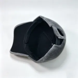 Close-up of the soft black inner lining of a stylish grey faux mink fur warm hat