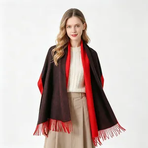 Modella che indossa uno scialle reversibile nero e rosso in finto cashmere con nappe