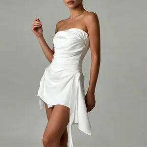 Side detail of a white strapless ruched dress featuring an asymmetric irregular hemline