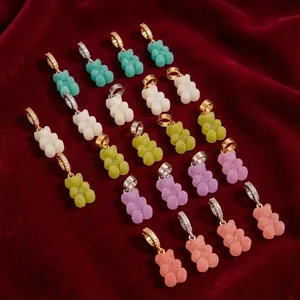 Detail view of colorful macaron gummy bear pendants with crystal bails on red velvet