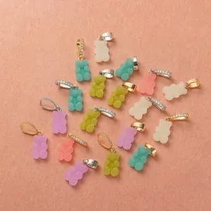 Macro view of macaron gummy bear charms in assorted colors with pave bails for DIY jewelry.