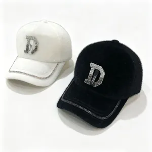 Vue détaillée des casquettes en fausse fourrure avec logo D en strass et chaîne