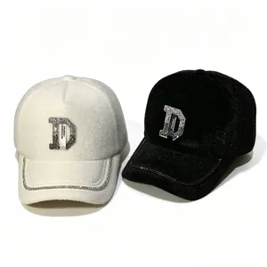 Gros plan sur des casquettes en fausse fourrure noire et blanche avec logo D en strass