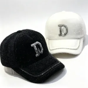 Vue détaillée des casquettes de baseball en fausse fourrure avec logo D en strass brillant.