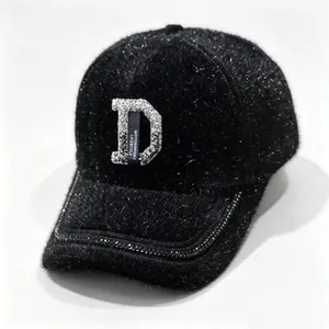 Gros plan détaillé d'une casquette en fausse fourrure noire avec strass lettre D