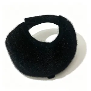 Gros plan sur la texture en fausse fourrure noire d'une visière d'hiver.